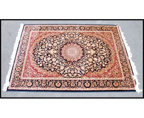 A large Iranian / Persian Keshan carpet - rug having blue and red ground with geometric decoration and borders. Measures 1.90