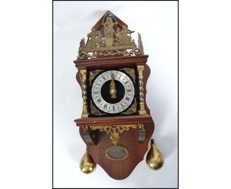 A contemporary burr walnut veneered Dutch wall hanging clock, showing Hercules holding up a globe as finial inscribed ' Nu El