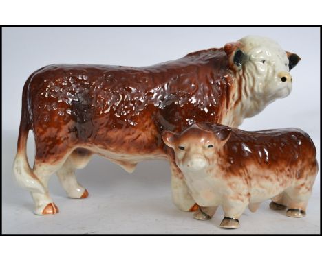 A large vintage 20th century ceramic Hereford Bull standing in usual pose together with another. Measures: 42cm long 