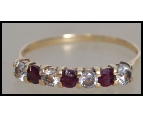 A hallmarked ruby and white stone half eternity ring. Hallmarked London. Size S.
