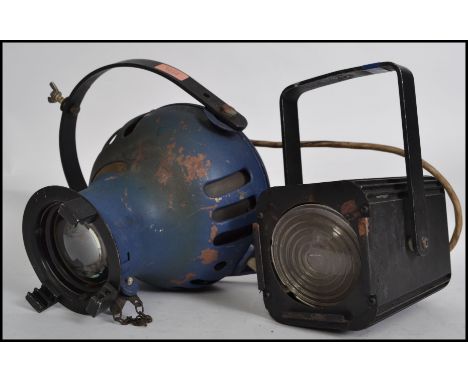 A vintage mid century Strand type theatre / cinema spot light together with another 20th century theatre light in blue by Fur