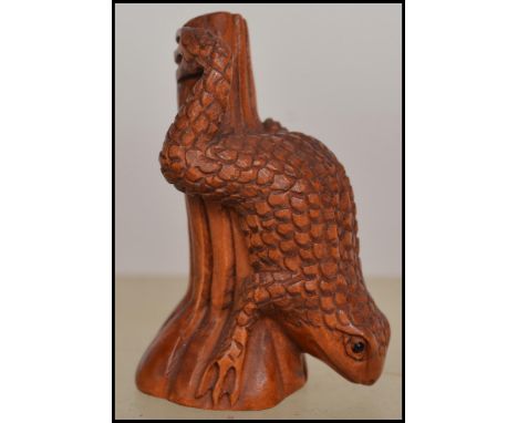 A carved Chinese / Japanese wooden netsuke in the form of a a frog on a tree. Measures 4.5cms high / weight 10.1g