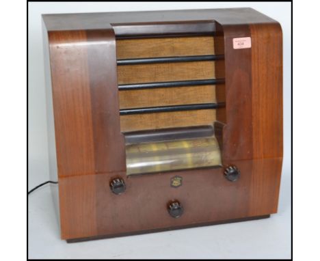 A vintage 20th century Peto Scott wooden cased valve radio. Having a central speaker to the front, knobs and dials to the top