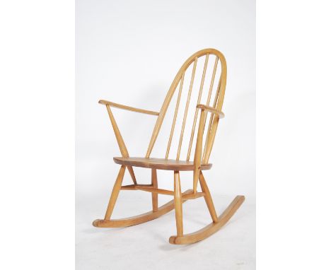 An Ercol 20th century blond wood retro rocking chair in the windsor pattern. Sleigh runners with turned legs and stretchers b