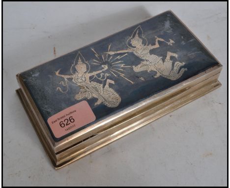 A 20th century vintage Siam sterling silver table top cigarette case with scenes of deity's to the hinged top having wooden s