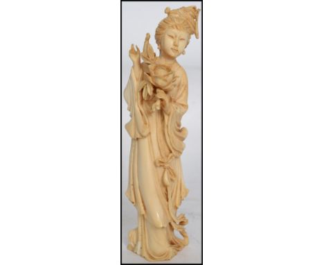 A Late 19th Early 20th Century Chinese Carved Ivory Figure in the form of a girl holding flowers.  Measures 17.5cms high  / c