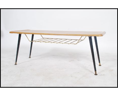 A vintage mid 20th century long john coffee table raised on splayed tapered legs united by a mesh work magazine rack.
