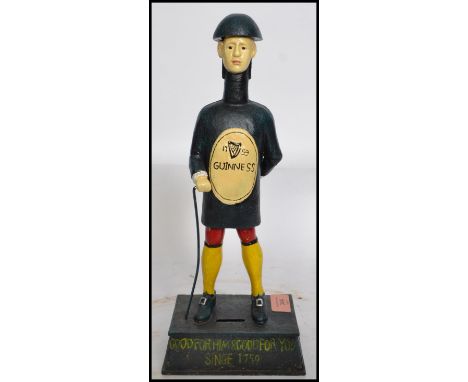 A vintage style advertising point of sale money bank figurine of a Guinness man raised on a plinth base with notation to fron