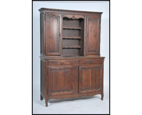 A 19th century French provincial oak dresser being raised on shaped legs with deep cupboards having an upright back with shel