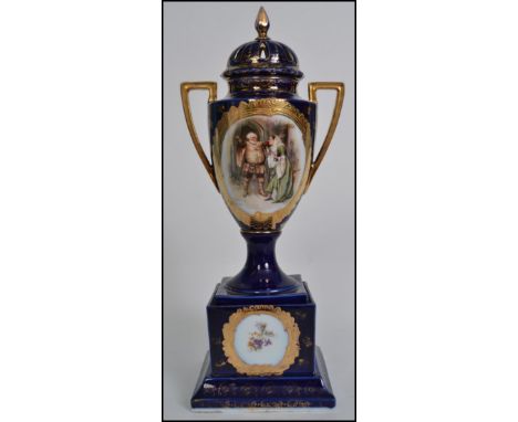 A 19th century Continental twin handled ceramic lidded urn, on cobalt blue ground with central panel scene of Falstaff meetin