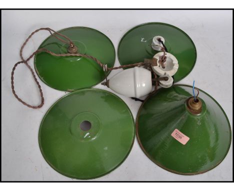 A vintage 20th century retro industrial rise and fall pendant shade lamp having three green enamel pendant UFO type shades al