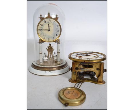 A vintage early 20th century Kaiser German glass domed anniversary mantle clock having a white enamel face raised on a painte
