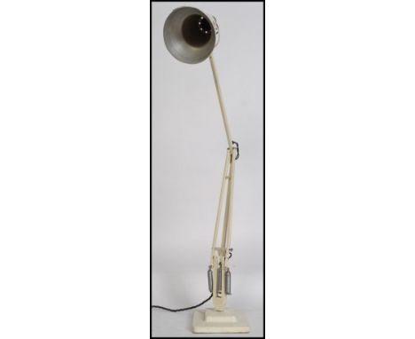 A vintage 20th century Herbert Terry anglepoise desk lamp being raised on terraced base with a pendant shade in white colourw