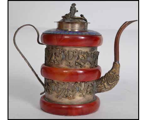 A very unusual silver on copper Oriental teapot having a shaped handle and spout having alternating red jade type and silver 