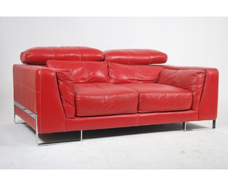 A contemporary red leather Italian sofa raised on strap chrome work legs and exterior frame, the deep sofa with re red stitch