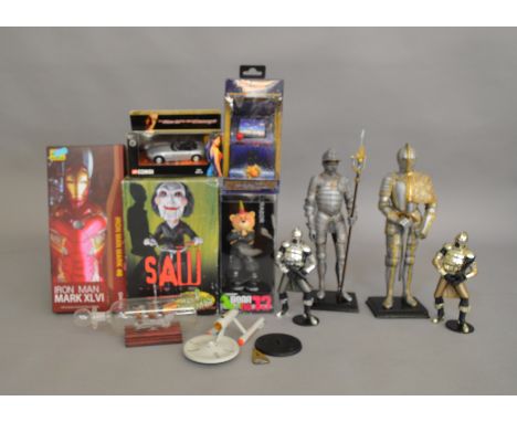 A mixed lot which includes; Iron man Mark XLV1 Collectible figure, a mini arcade machine, Saw head knocker etc.