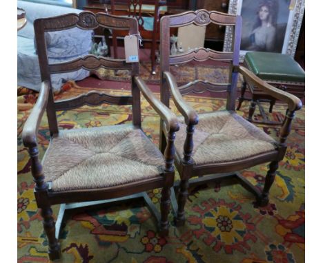 A pair of early 20th Century oak open armchairs with ladder backs and rush seats, H.95cm (2) 