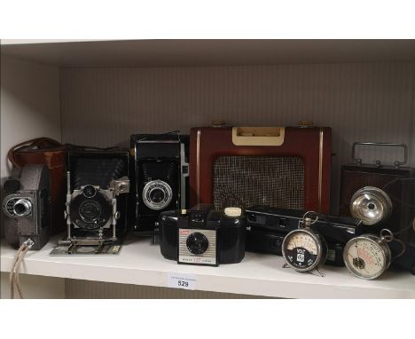 Large shelf of assorted bellows camera etc. 