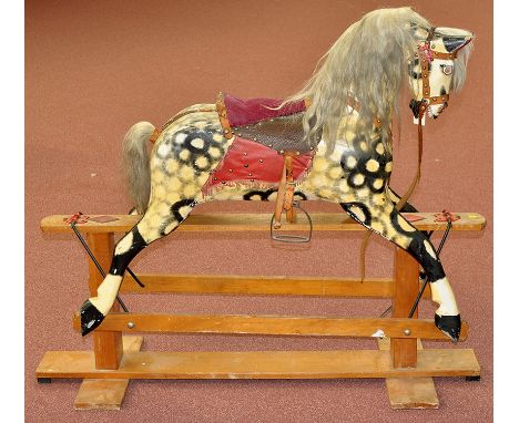 An early 20th Century rocking horse, painted dapple grey with leather tack and saddle, horsehair mane and tail, raised on lig