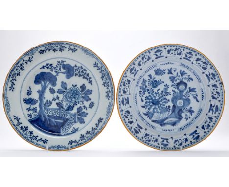 Two Delftware blue and white dishes, painted with floral and garden scenes enclosed by floral borders and yellow rims, possib