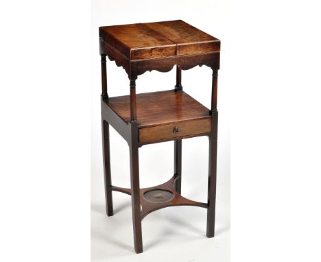 A George III mahogany washstand, the square top opening to reveal cut out basin and beaker stands, shaped frieze below raised