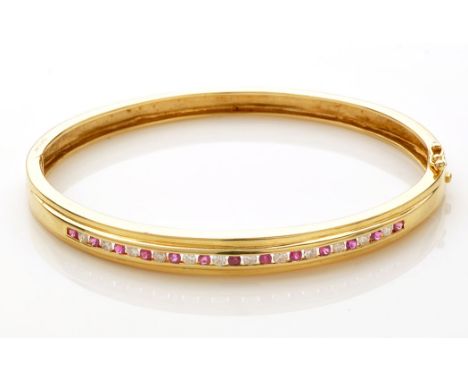 A ruby and diamond bangle, the circular facet cut rubies and brilliant cut diamonds channel set in 18ct. yellow gold mount, s