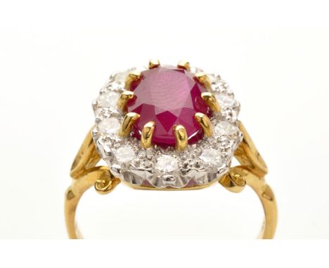 A ruby and diamond cluster ring, weighing approximately 2.80 carats, claw set surrounded by ten brilliant cut diamonds in ill