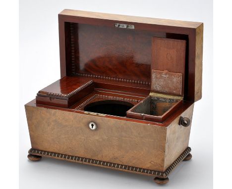 An early 19th Century mahogany tea caddy, the lid with gadrooned edges opening to reveal fitted interior with two pull out ca