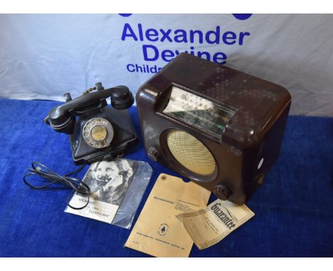 A Bakelite Art Deco radio, in brown, together with a black Bakelite telephone with a 1950s Manual 'Speaking on the Telephone'