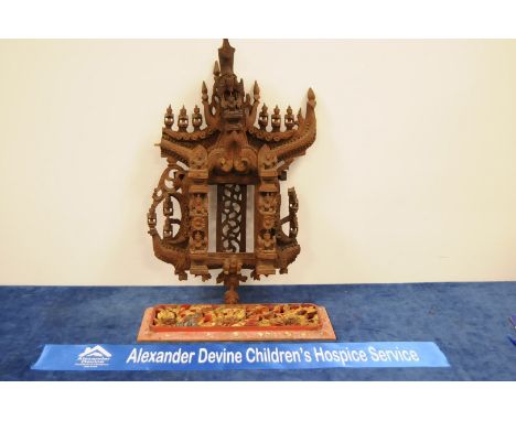 A Thai carved hardwood wall hanging temple scene, 59cm high (af) together with a gilt painted carved and moulded rectangular 