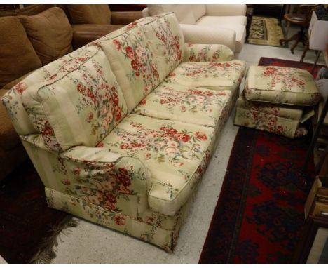 A three seat sofa with Colefax and Fowler fabric upholstery raised on block feet together with matching pouffé