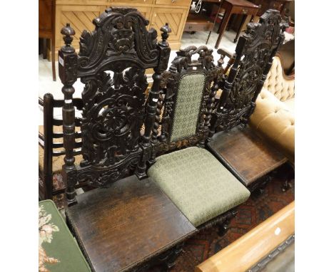 A pair of 19th Century Carolean style oak  hall chairs with carved backs together with a similar hall chair with upholstered 