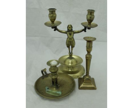 An 18th Century brass figural twin branch candlestick on a stepped base with drip tray together with a single brass candlesti