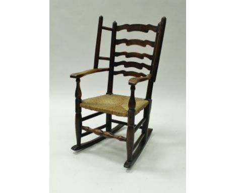 A 19th Century Dales ash ladder back rush seated wingback chair on turned legs and rockers 