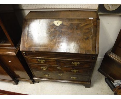 An early 18th Century walnut bureau, the inlaid top over a sloping fall enclosing a fitted interior with well, over two short