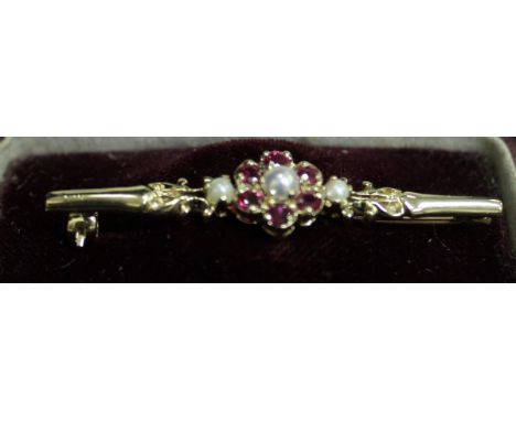 A 9ct gold Victorian style ruby and pearl flower head design brooch flanked by two further seed pearls