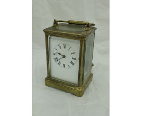 A circa 1900 lacquered brass cased carriage clock with white enamel dial and Roman numerals