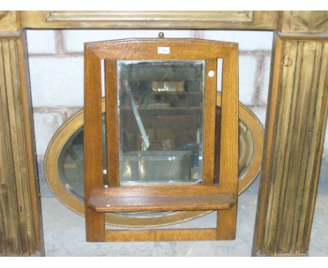 An Oak hanging mirrored wall shelf and an oval gilt framed wall mirror. (2)