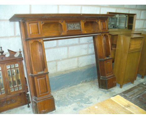 A Victorian walnut fire surround , the rectangular moulded top above a central panel carved with flowerheads , flanked by two