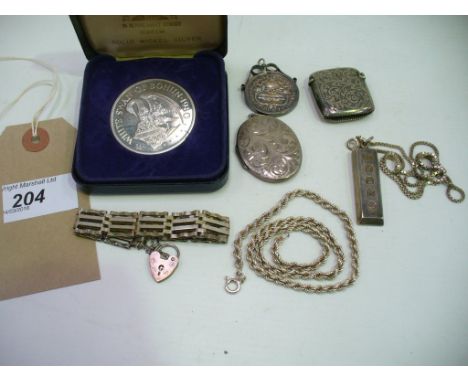 A collection of silver and plated items
To include, a locket, a vesta case, two coins, a chain, an ingot pendant and chain, a