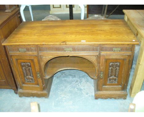 A Late Victorian oak dressing table , the rectangular top above three frieze drawers and a central shaped under shelf flanked