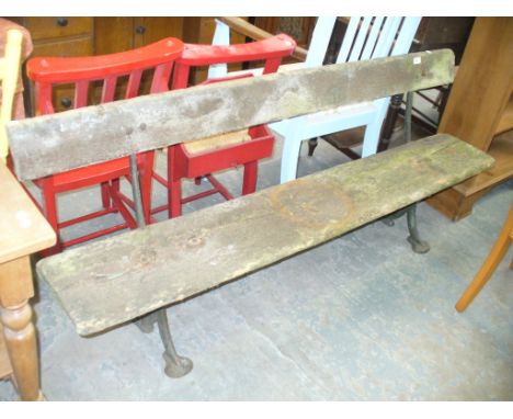 A Hardwood garden bench with a single back rail raised on two cast iron bracket supports.