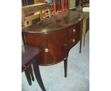 A Regency style mahogany bow front sideboard with two convex drawers flanked by two cupboard doors, tapering legs of square s