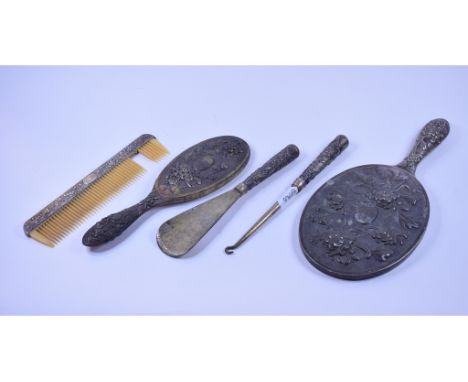 A Chinese silver coloured metal mounted part dressing table set, initialled, embossed flowers and foliage, comprising a hand 