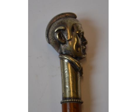 A malacca walking cane, the plated handle cast in the form of a man with a moustache wearing a helmet and a tie, 86 cm high