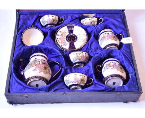 A Japanese Satsuma earthenware tea set, decorated panels of figures on a blue and gilt ground, some rubbing, one cover repair