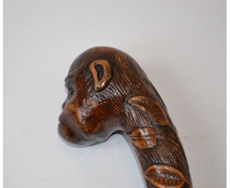 A carved wood folk art walking cane, the shaft decorated tools, animals and other motifs, with bead decoration, the handle in