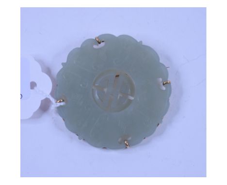 A jade pendant/disc, with carved and pierced decoration, in a gold mount, 5.5 cm diameter   Condition report  Report by GHSom