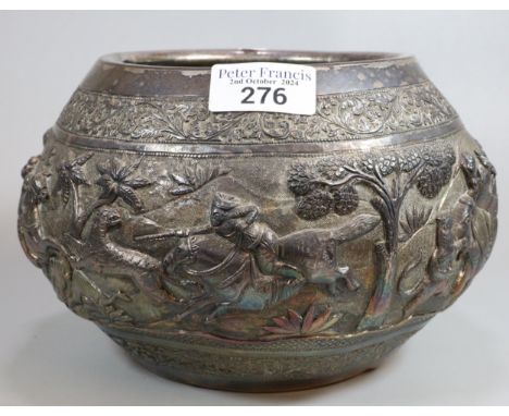 Indian/Burmese circular bowl, chased in bold relief with a hunting party under attack with various animals including: Elephan