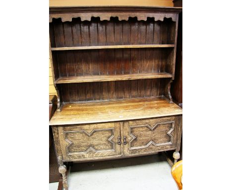 A VINTAGE CARVED DRESSER WITH OPEN RACK and two-cupboard base